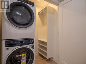 Toronto (Junction Area) apartment for rent - A white washing machine is in a small laundry room.