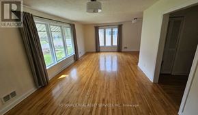 Ottawa apartment for rent - A room with wooden floors and a large window.