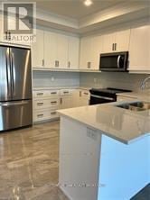 London North (North R) condo for rent - A kitchen with a white counter top and a stainless steel refrigerator.