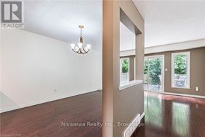 Waterloo townhouse for rent - A room with a chandelier and a window overlooking a backyard.