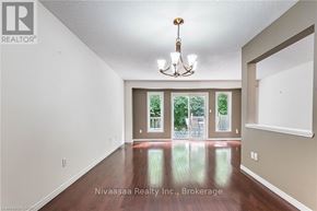 Waterloo townhouse for rent - A well-lit room with a chandelier and a view of trees through the windows.