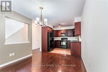 Waterloo townhouse for rent - A well-lit kitchen with dark wood cabinets and a chandelier.