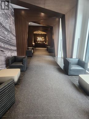 Toronto (Church-Yonge Corridor) condo for rent - A hallway with a carpeted floor and a stone wall on the left side.