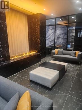 Toronto (Church-Yonge Corridor) condo for rent - A living room with a grey sofa and a fireplace.