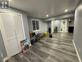 Kitchener apartment for rent - A room with a grey floor and white walls has a sign that says EXP REALTY, Brokerage.