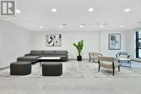 Ottawa apartment for rent - A living room with a grey sofa set and a large plant in the middle.