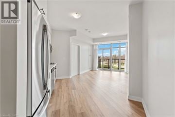 Stoney Creek condo for rent - A modern kitchen with a refrigerator and wooden flooring.