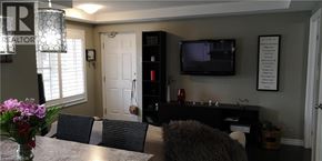 Kitchener condo for rent - A living room with a grey couch and a black entertainment center.