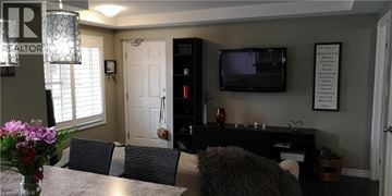 Kitchener condo for rent - A living room with a grey couch and a black entertainment center.