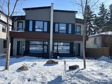 Calgary apartment for rent - A modern house with a large front yard covered in snow.