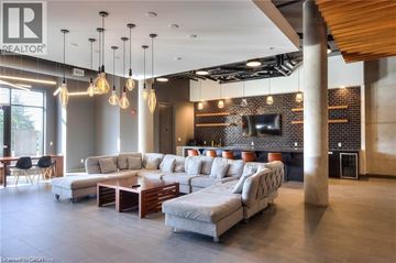 Waterloo condo for rent - A modern living room with a large sectional sofa and a wooden coffee table.
