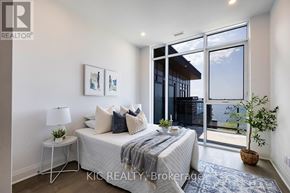 Kawartha Lakes (Fenelon Falls) condo for rent - A bedroom with a bed, nightstand, and a window with a view of the outside.