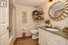 Welland (Prince Charles) condo for rent - A bathroom with a toilet, sink, and mirror.