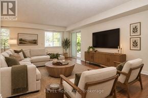 Welland (Prince Charles) condo for rent - A living room with a white couch, a wooden coffee table, and a flat-screen TV mounted on the wall.