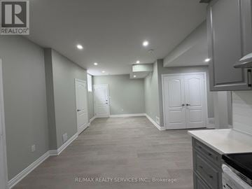 Brampton (Northwest Brampton) apartment for rent - A spacious kitchen and dining area with white cabinets and a grey floor.