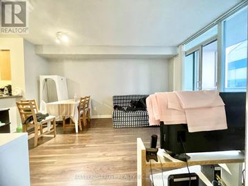 Toronto (Lansing-Westgate) condo for rent - A living room with a black couch and a white table.