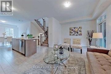 Vaughan (Maple) townhouse for rent - A modern living room with a glass coffee table and a brown sofa.