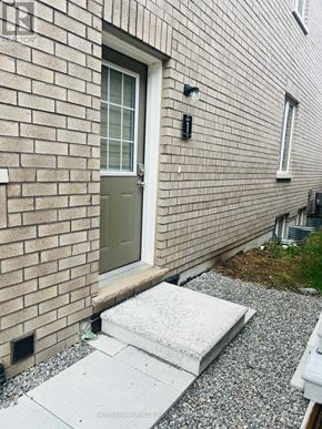 Barrie apartment for rent - A grey door is on a brick building.