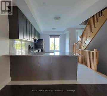 Mississauga (Lakeview) townhouse for rent - A modern kitchen with dark wood cabinets and a stainless steel refrigerator.