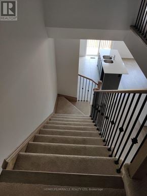 South-West Oxford townhouse for rent - A staircase with a carpeted runner and black metal balusters.
