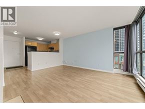 Burnaby apartment for rent - A spacious room with wooden flooring and a large window.