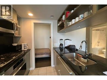 Vancouver apartment for rent - A living room with a couch and a kitchen area in the background.