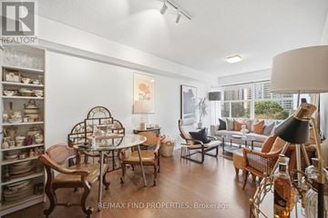 Toronto (University) condo for rent - A well-lit living room with a dining table and chairs.