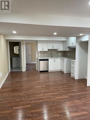 Oshawa (Windfields) apartment for rent - A kitchen with white cabinets and a wooden floor.