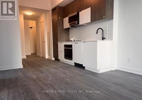 Richmond Hill (South Richvale) condo for rent - A kitchen with white appliances and wooden cabinets.