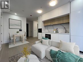 Toronto (Playter Estates-Danforth) condo for rent - A modern living room with a white couch and a dining table.