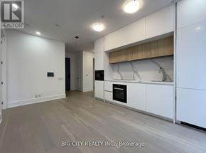 Toronto (Playter Estates-Danforth) condo for rent - A spacious kitchen with white cabinets and a wooden countertop.