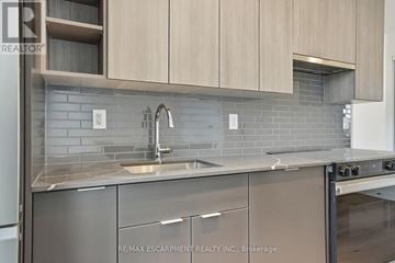 Burlington (Brant) condo for rent - A modern kitchen with a sink and stove top oven.
