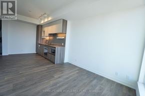 Vaughan (Vaughan Corporate Centre) condo for rent - A spacious room with wooden flooring and a built-in cabinet with a microwave and oven.