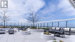 Vaughan (Vaughan Corporate Centre) condo for rent - A rooftop patio with a table and chairs overlooking the city.