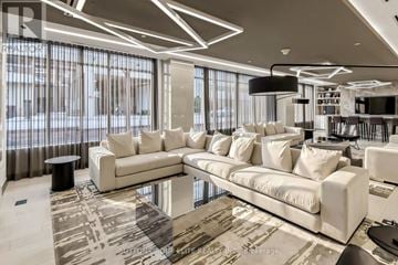 Toronto (Kensington-Chinatown) condo for rent - A modern living room with white furniture and a large window.