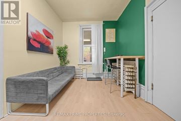 Ottawa multi-family for rent - A living room with a grey couch and a green wall.