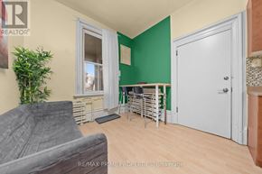 Ottawa multi-family for rent - A living room with a grey couch and a green wall.