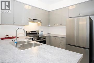 Brantford townhouse for rent - A kitchen with a sink, stove, and refrigerator.