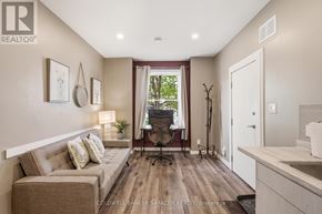 Ottawa multi-family for rent - A well-lit, modern living room with a couch, chair, and a window with a view.
