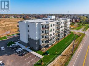 Thorold (Thorold Downtown) multi-family for rent - A large white apartment building with a parking lot in front.