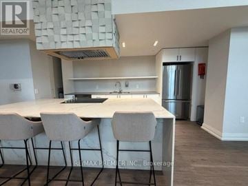 Barrie (Little Lake) condo for rent - A kitchen with a white countertop and bar stools.