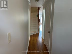 Huntsville (Chaffey) townhouse for rent - A hallway with a wooden floor and white walls.