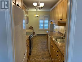 Huntsville (Chaffey) townhouse for rent - A kitchen with wooden cabinets and a white refrigerator.