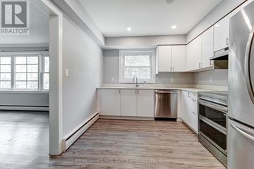 Oakville (Oo Old Oakville) triplex for rent - A kitchen with white cabinets and stainless steel appliances.