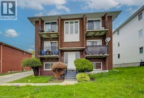 Kitchener apartment for rent - A two-story brick apartment building with a balcony on the second floor.