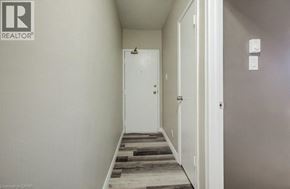 Kitchener apartment for rent - A hallway with a door on the left and a light switch on the wall.
