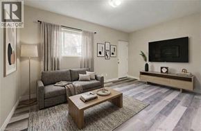 Kitchener apartment for rent - A living room with a grey couch, a wooden coffee table, and a flat screen TV mounted on the wall.