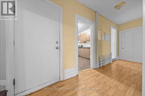 Ottawa multi-family for rent - A room with a white door and a yellow wall.