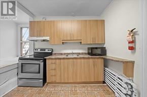 Ottawa multi-family for rent - A kitchen with wooden cabinets and a stove top oven.
