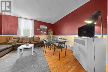 Ottawa multi-family for rent - A living room with a grey sofa, a white coffee table, and a television on a cabinet.